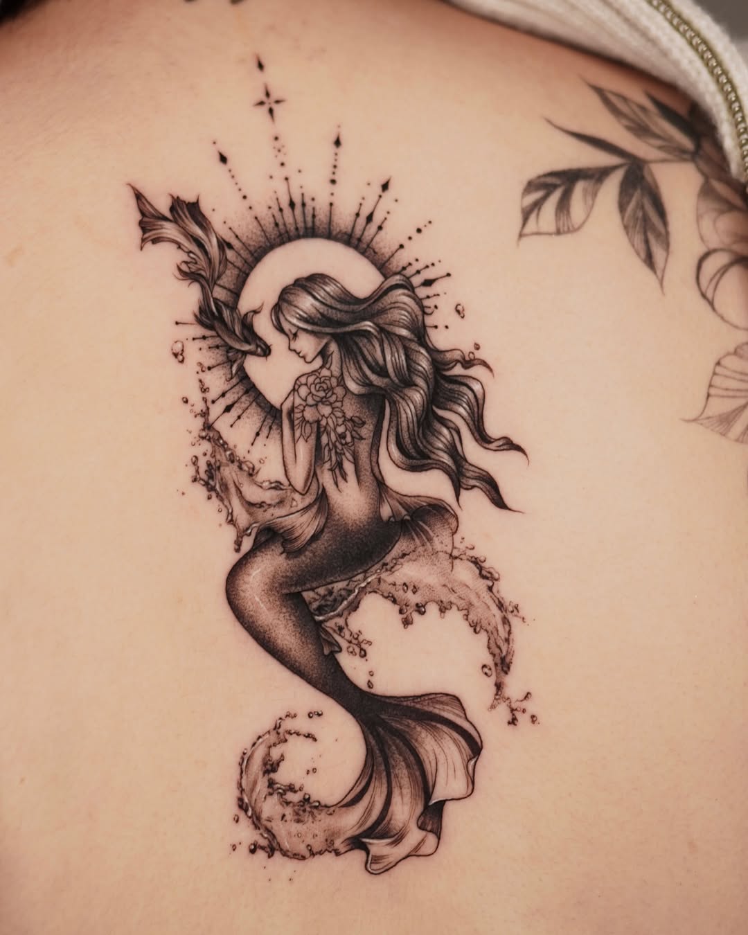 Elegant mermaid tattoo with celestial elements