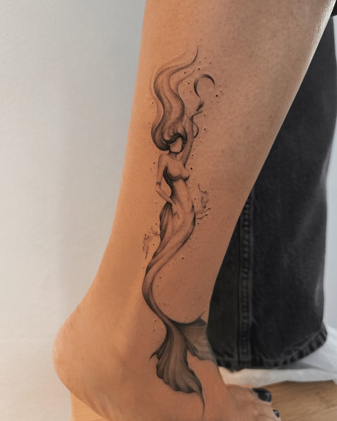 Elegant mermaid tattoo on the leg