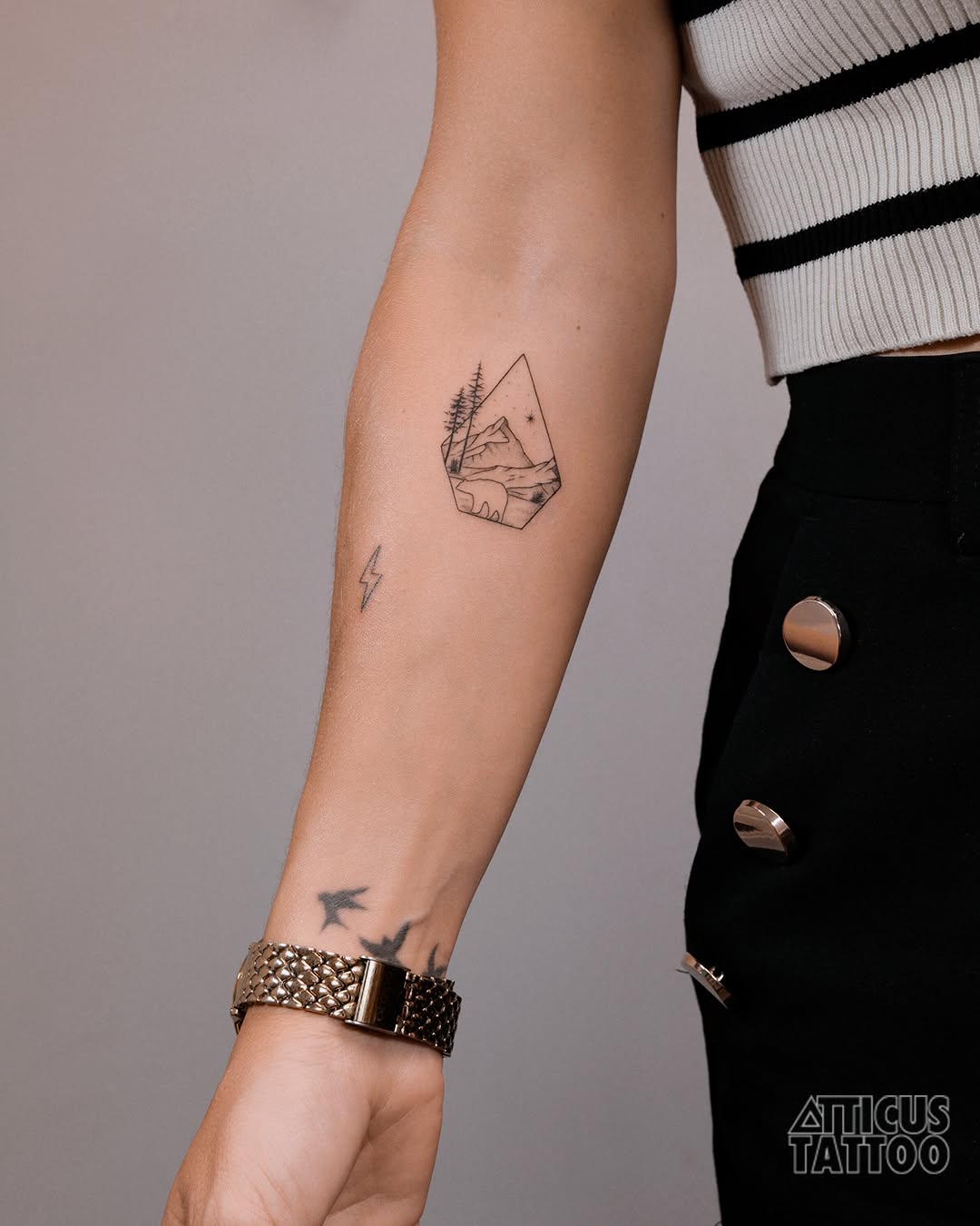 Stylish minimalist mountain tattoo on forearm