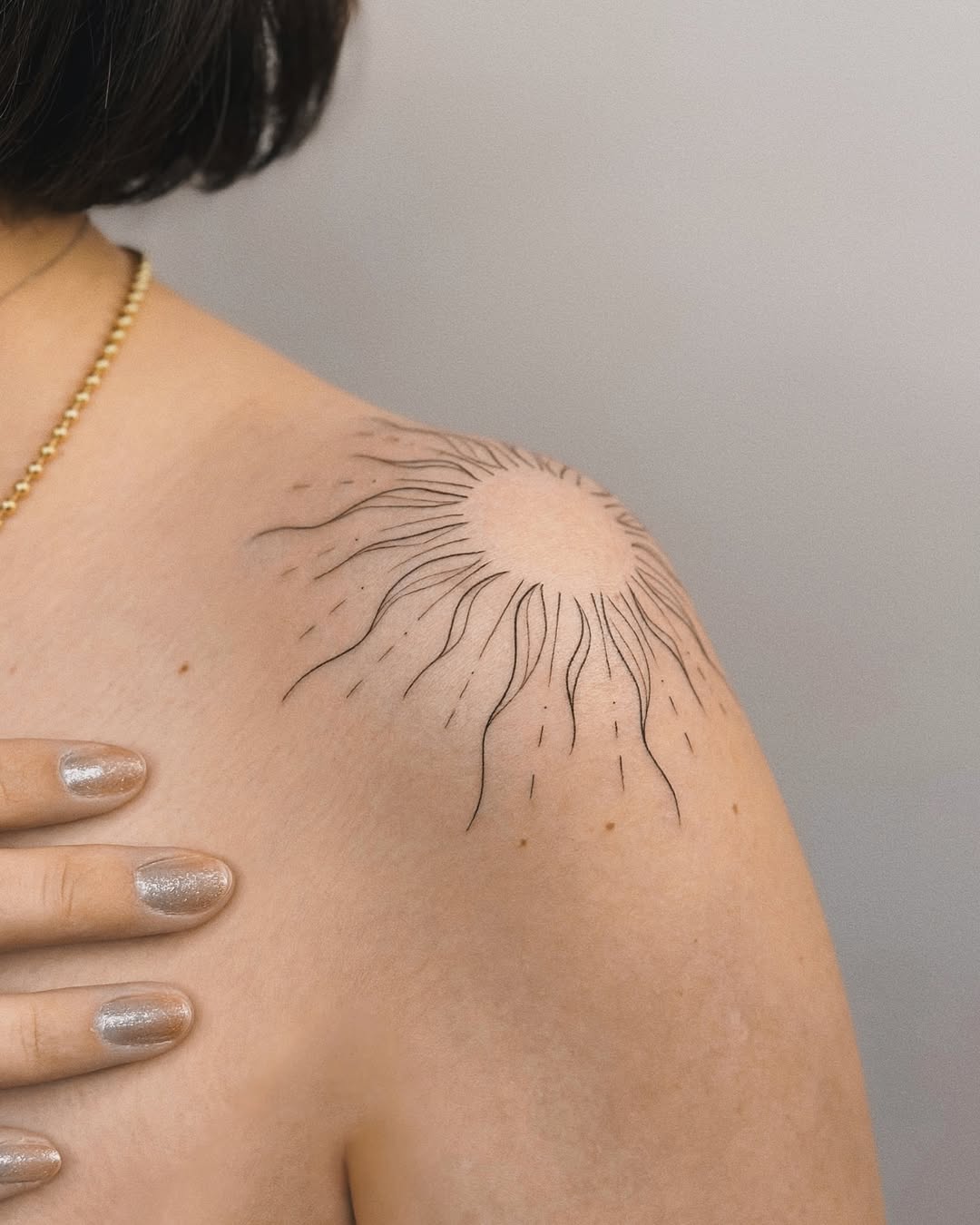 Elegant sun tattoo with radiant lines