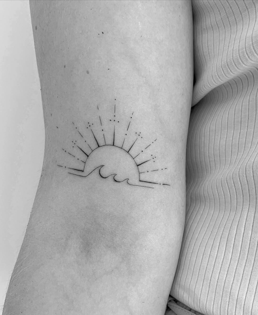 Stunning minimalist sun and wave tattoo design.