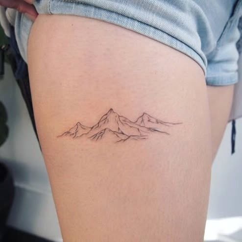 Delicate mountain tattoo on the thigh