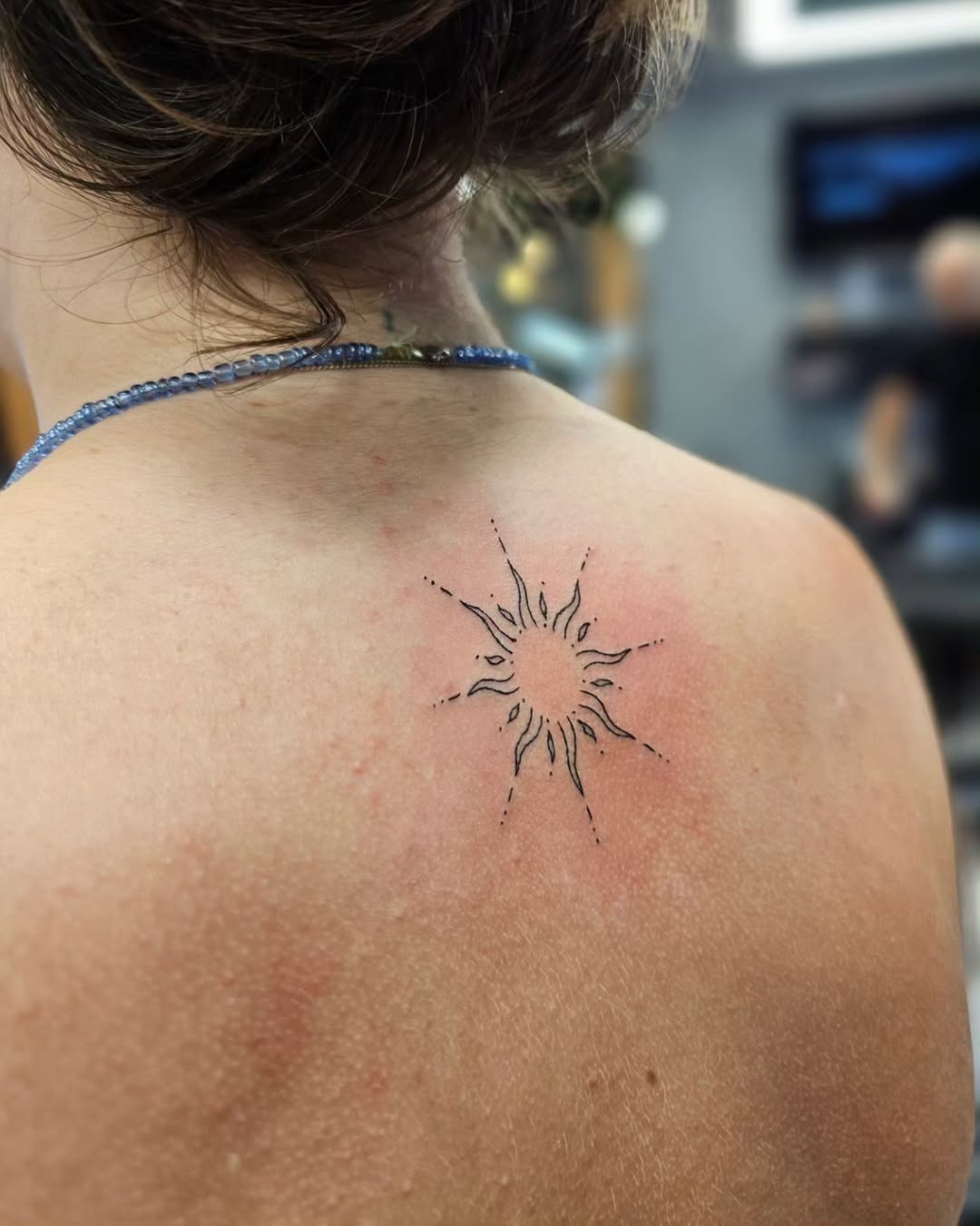 Charming sun tattoo shining on the back