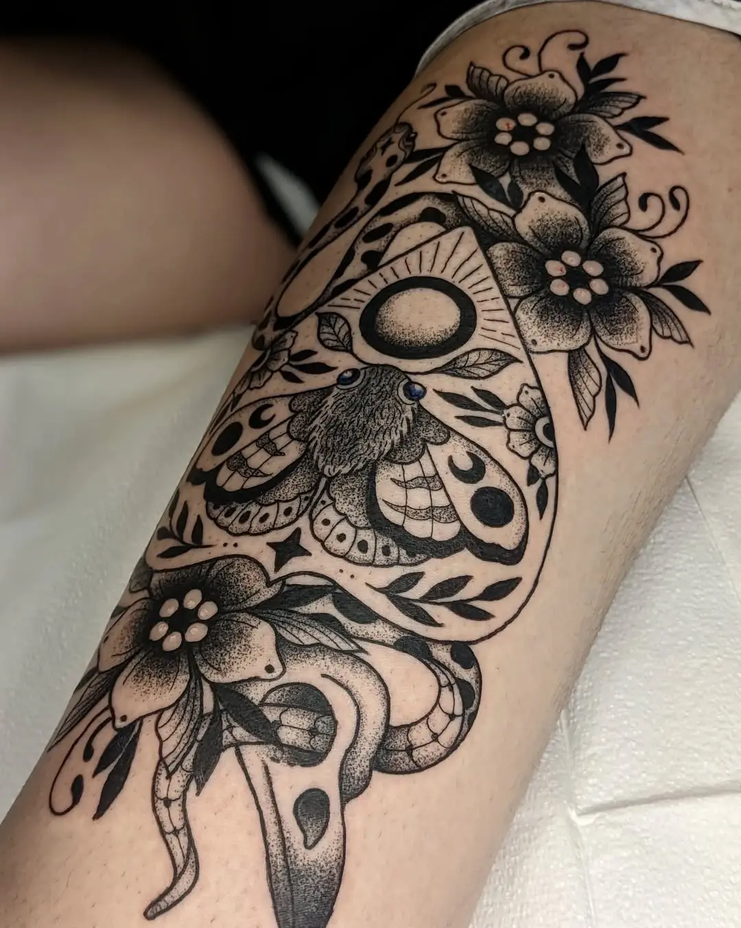 Elegant moth tattoo adorned with floral details