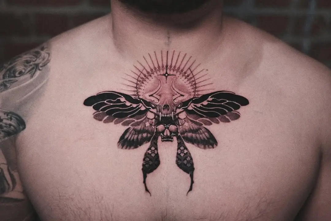 Intricate moth tattoo with celestial elements