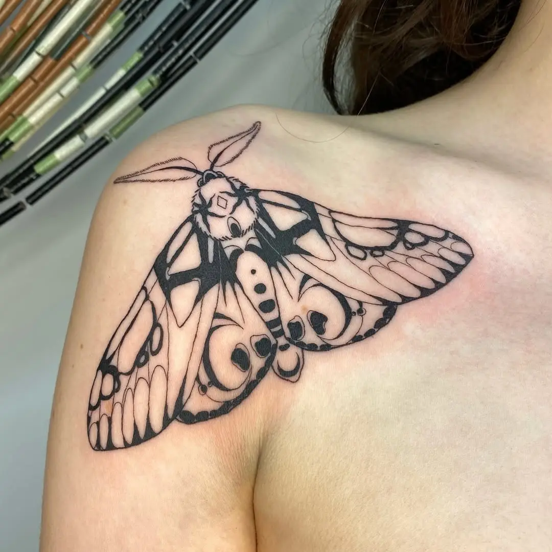 Elegant black and white moth shoulder tattoo