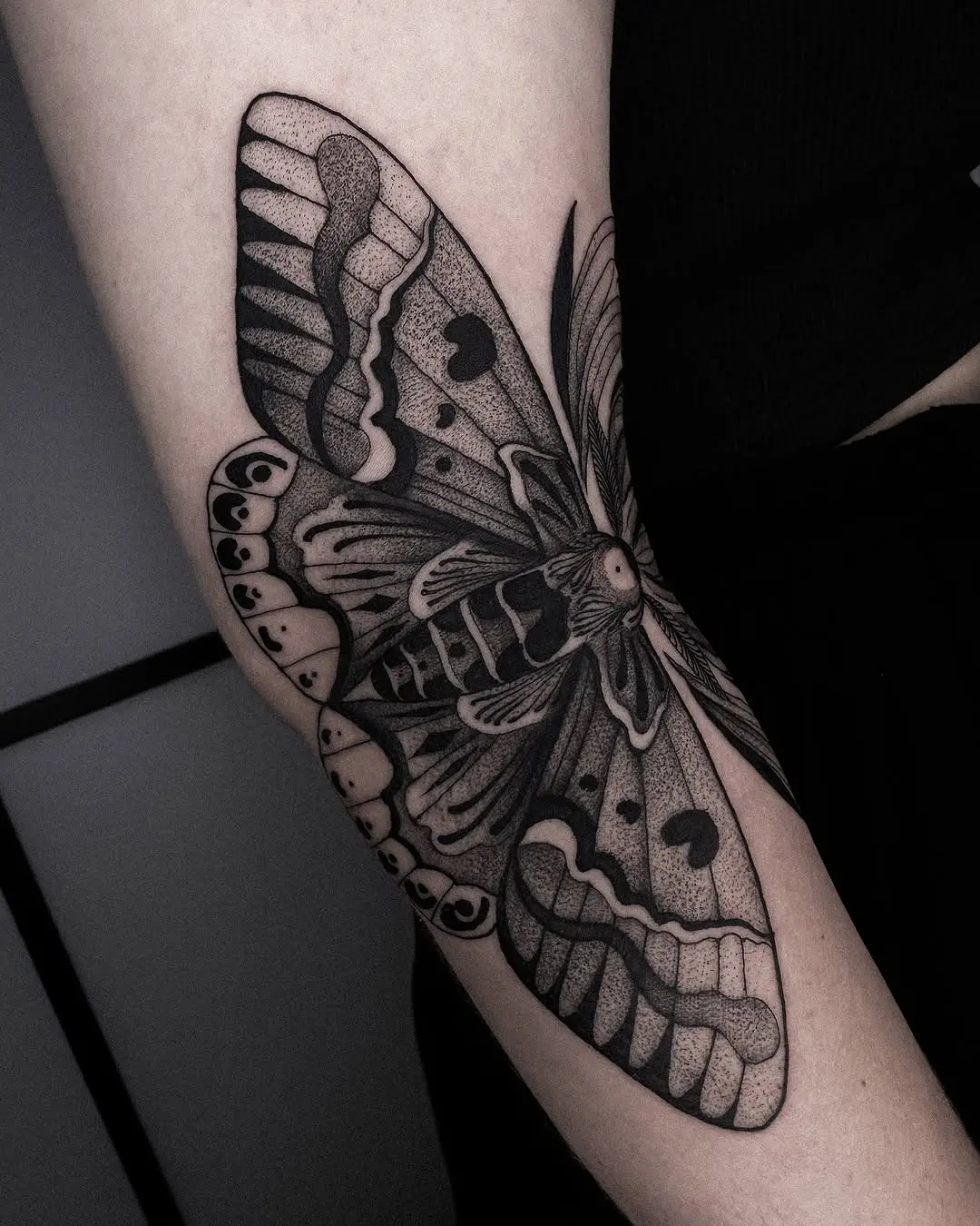Stunning blackwork moth tattoo on forearm