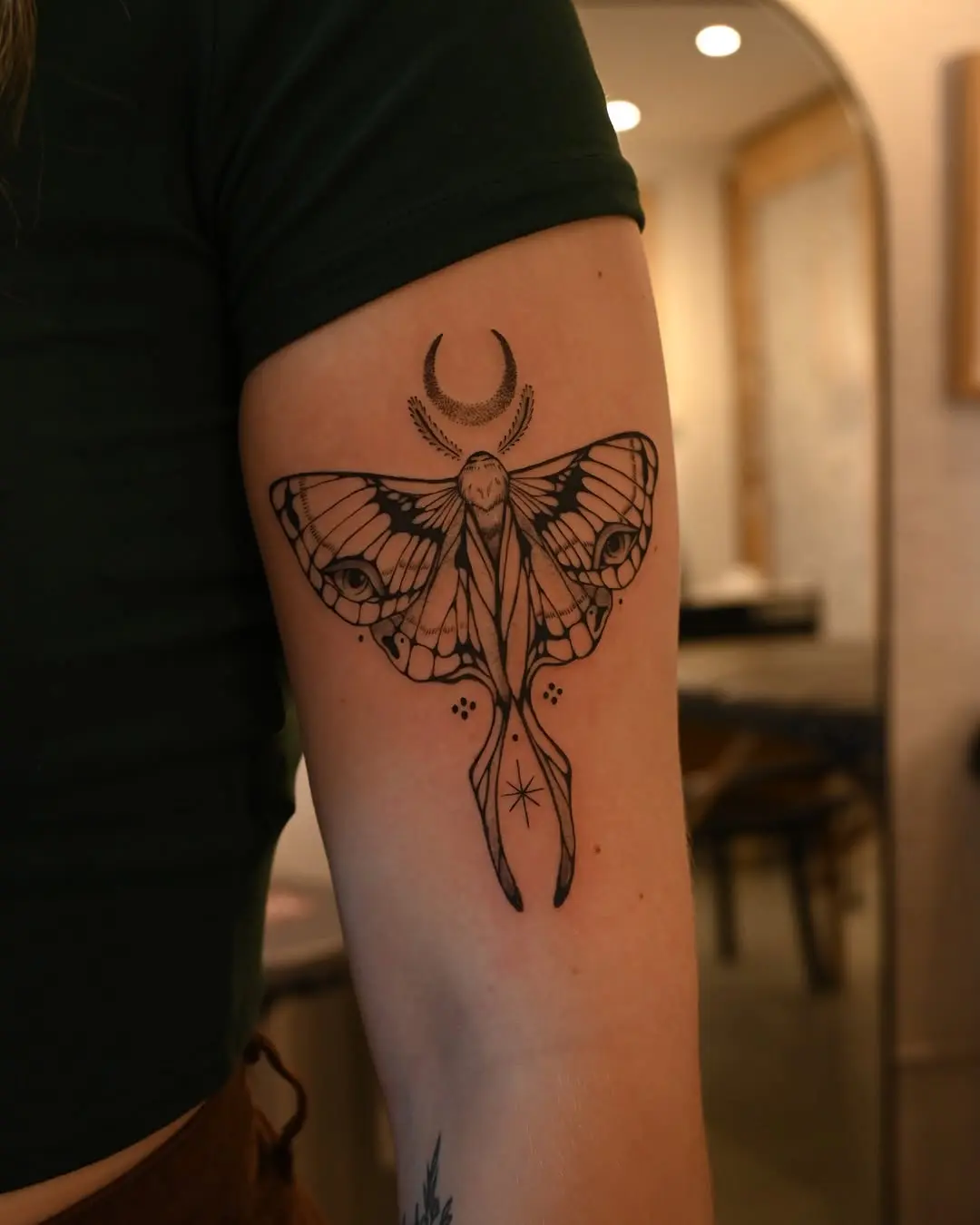 Elegant moth tattoo with celestial elements