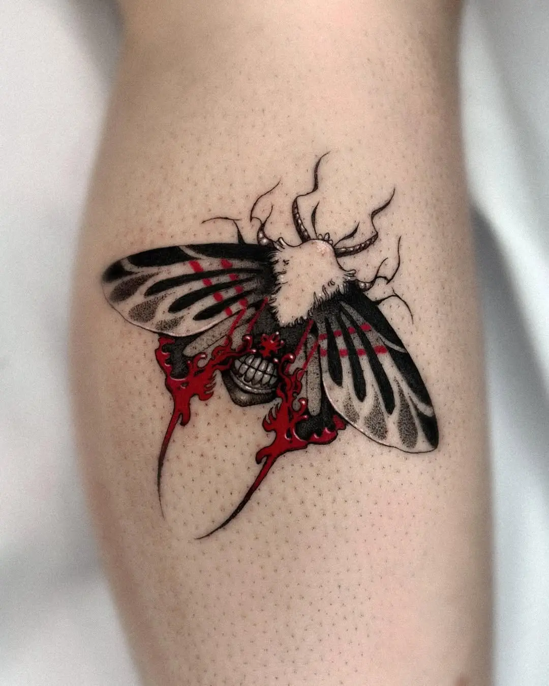 Bold Moth Tattoo with Striking Red Accents