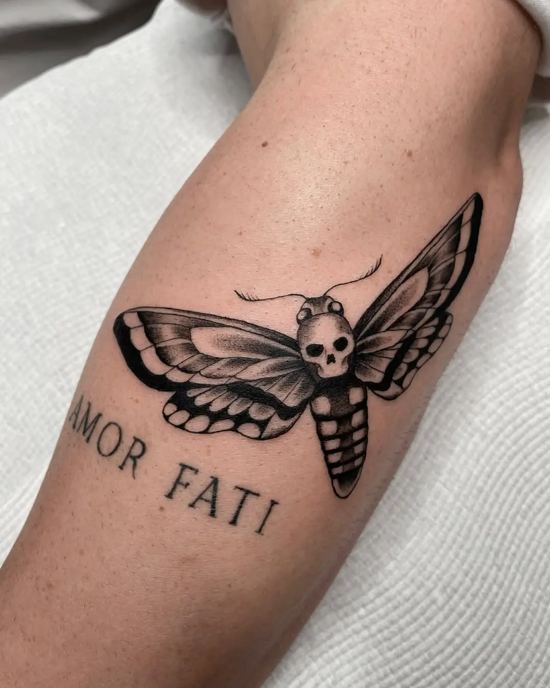 A striking moth tattoo with a skull motif