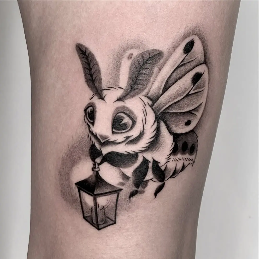 Charming moth tattoo with a whimsical lantern
