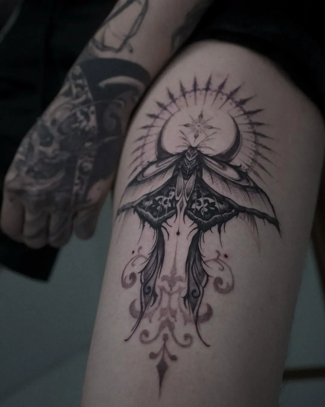 Intricate moth tattoo with celestial elements