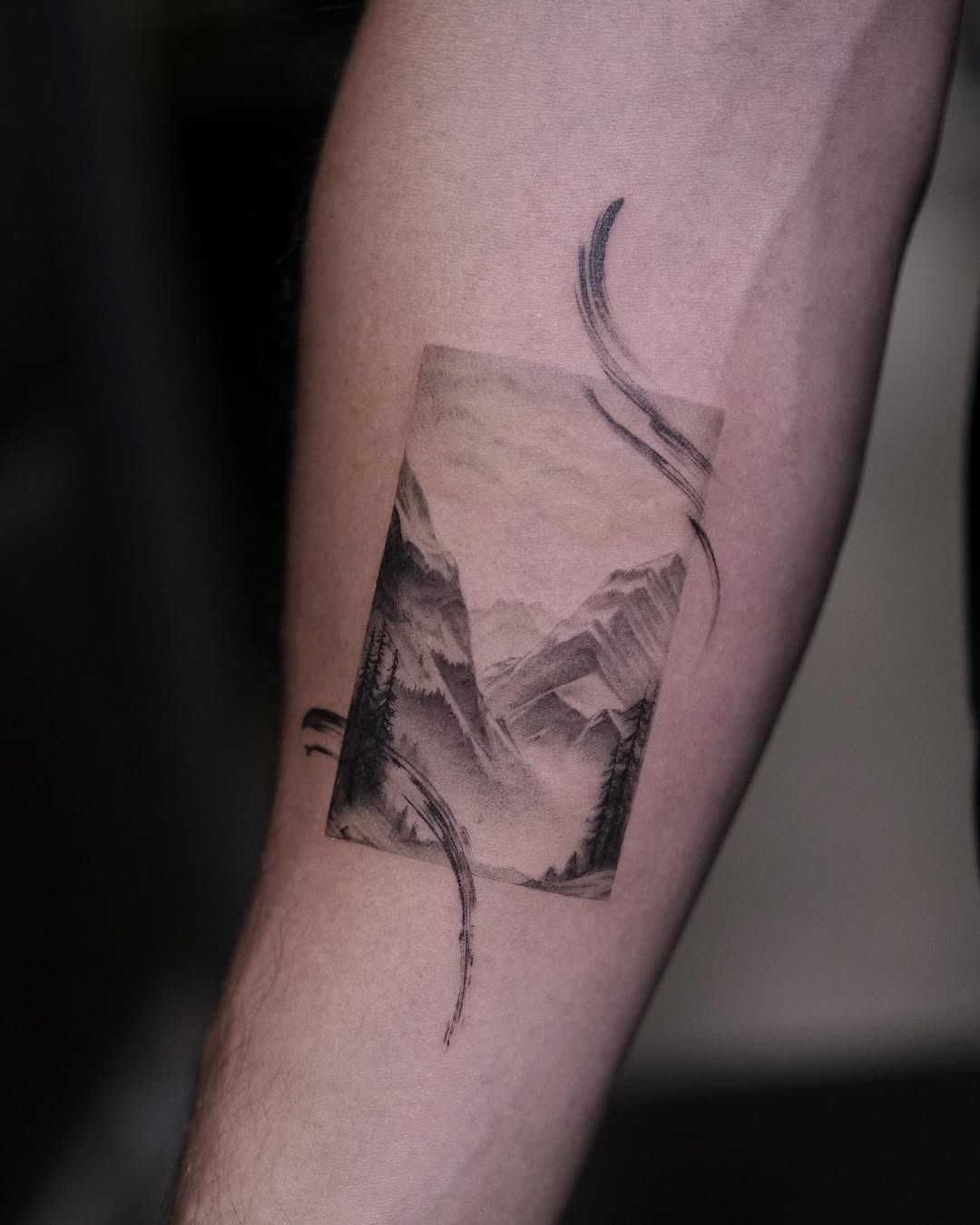 Artistic mountain landscape tattoo on forearm