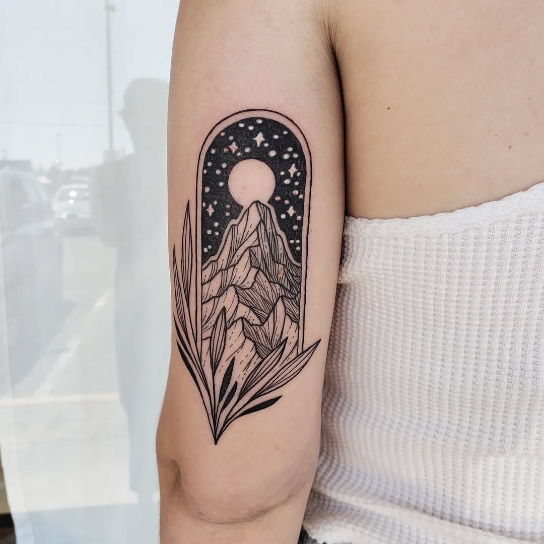 A striking mountain tattoo with celestial elements