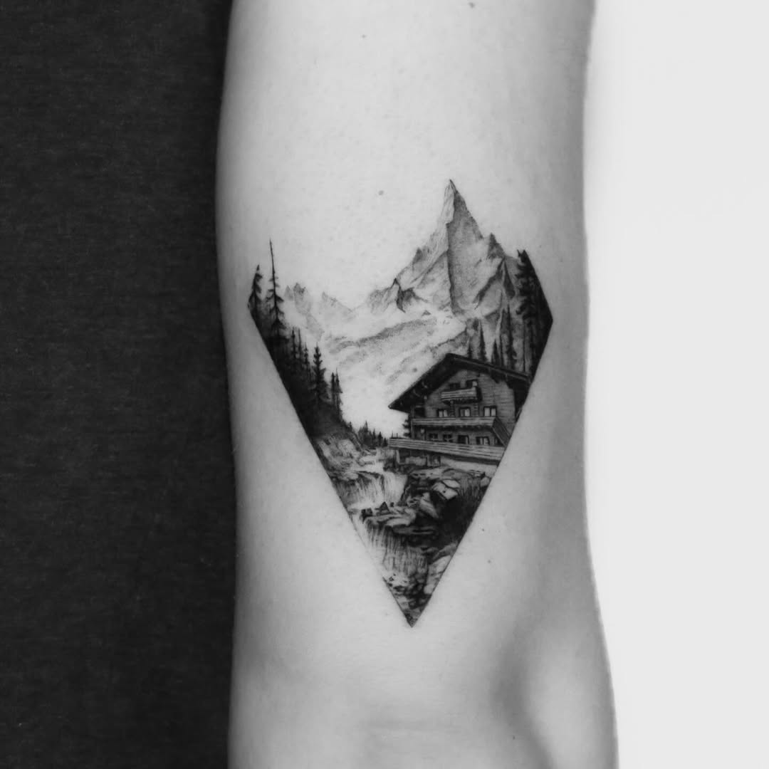 Stunning mountain landscape tattoo with cabin detail