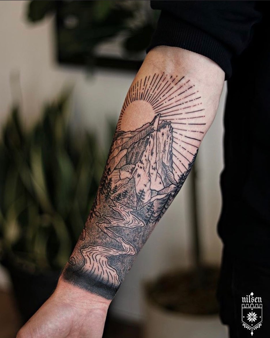 Stunning mountain scenery tattoo on forearm