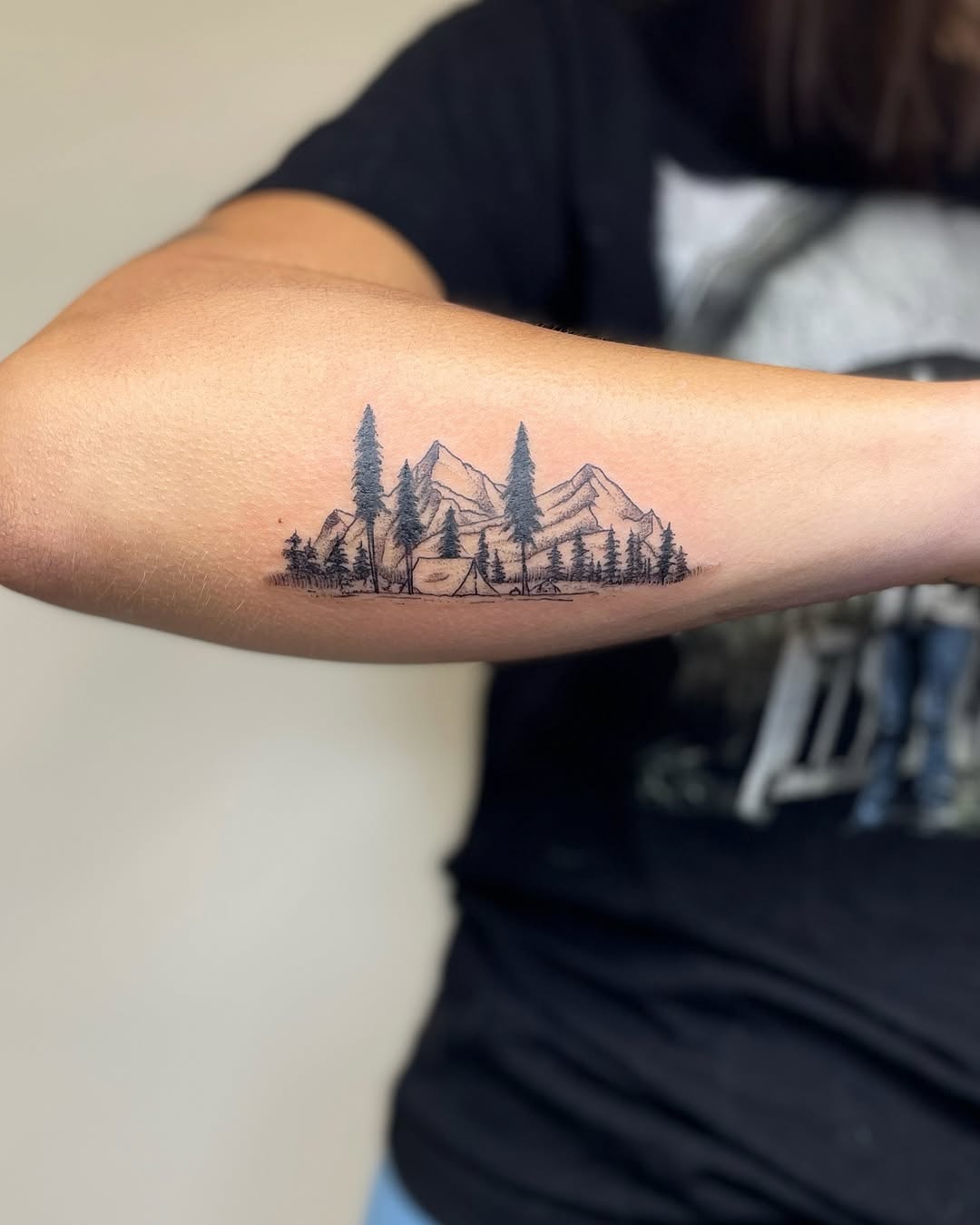 Stylish mountain scene tattoo with camping vibes