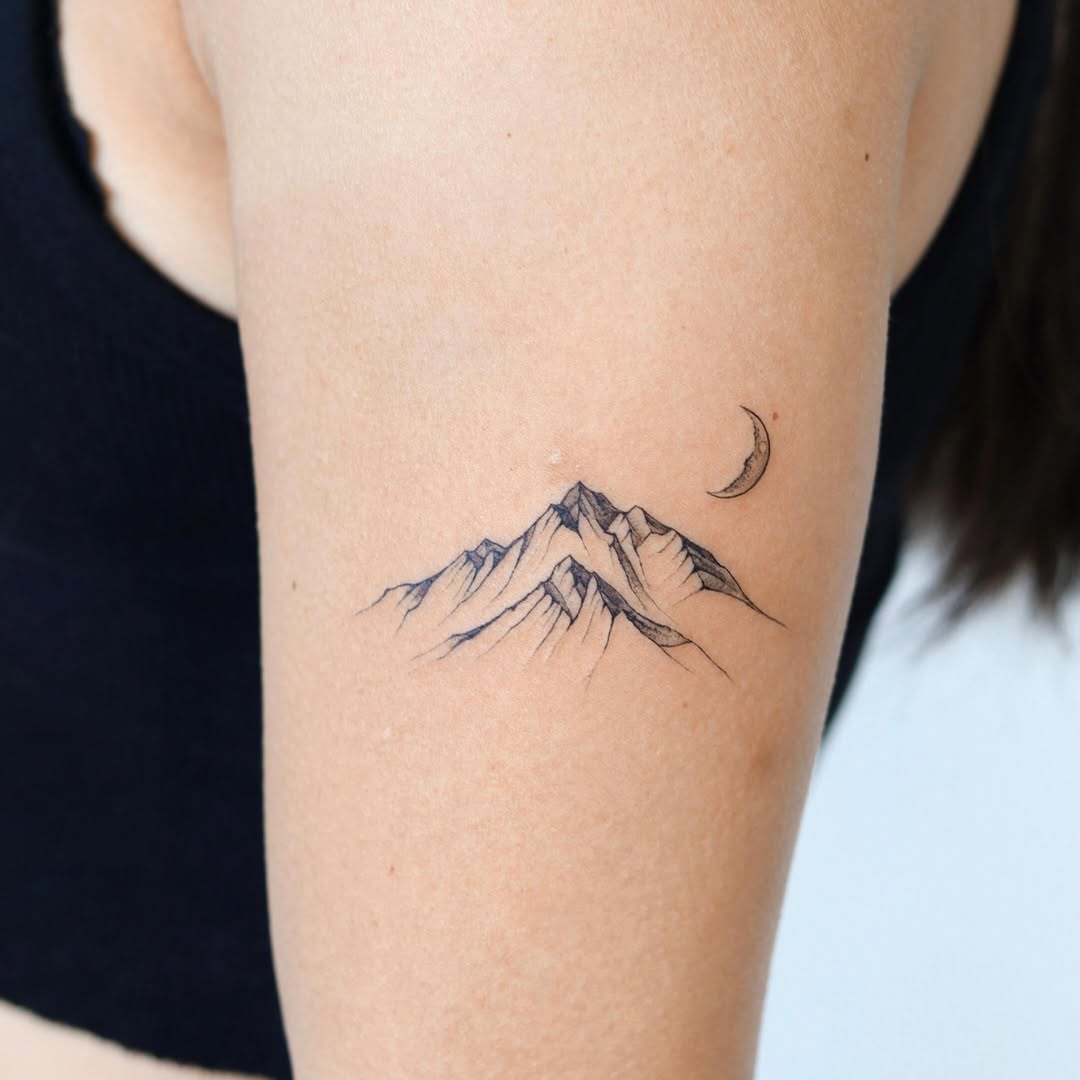 Elegant mountain tattoo with a crescent moon