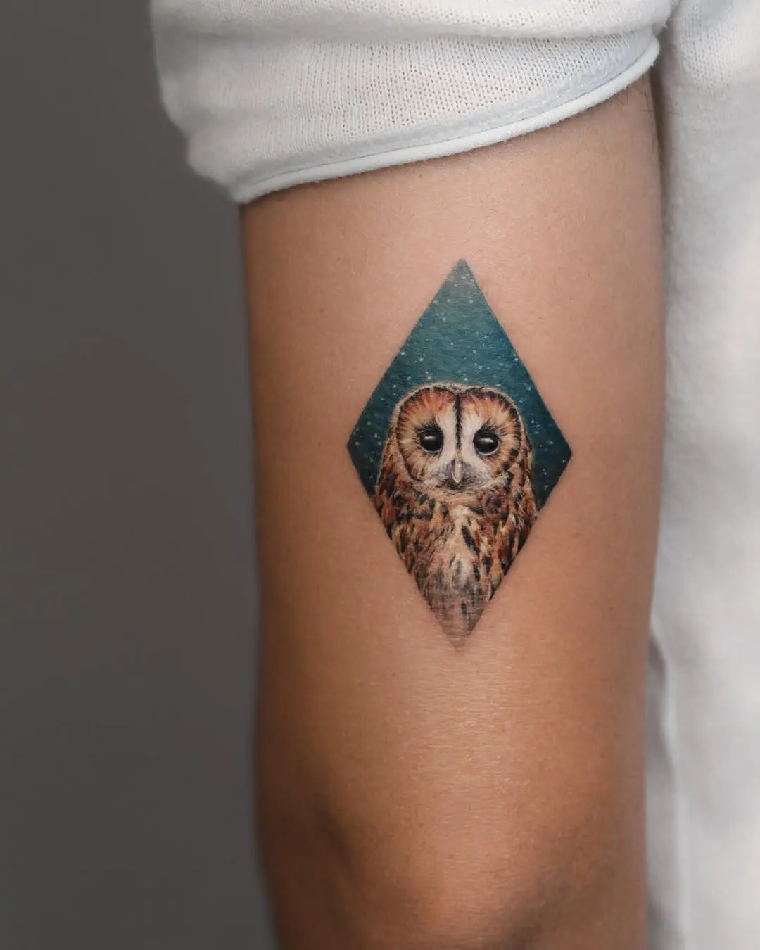 Unique owl tattoo in diamond-shaped design