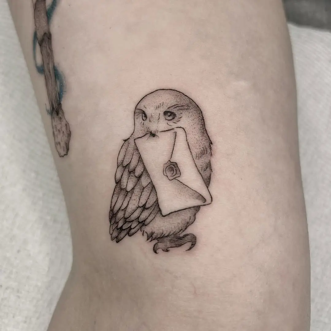 Charming owl tattoo holding a letter