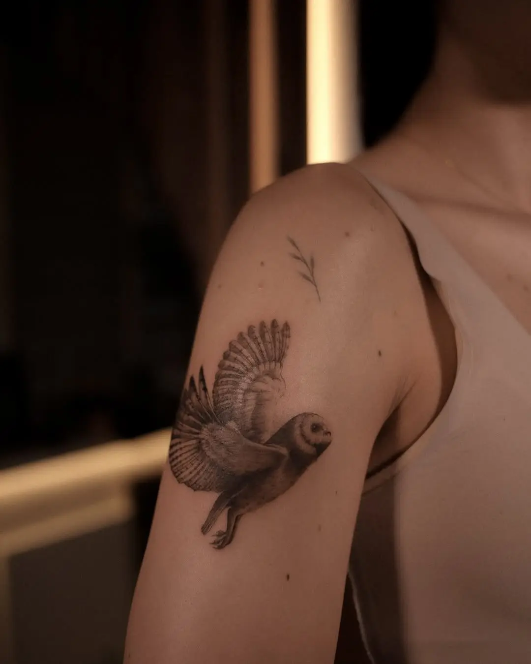 Elegant flying owl tattoo on the arm