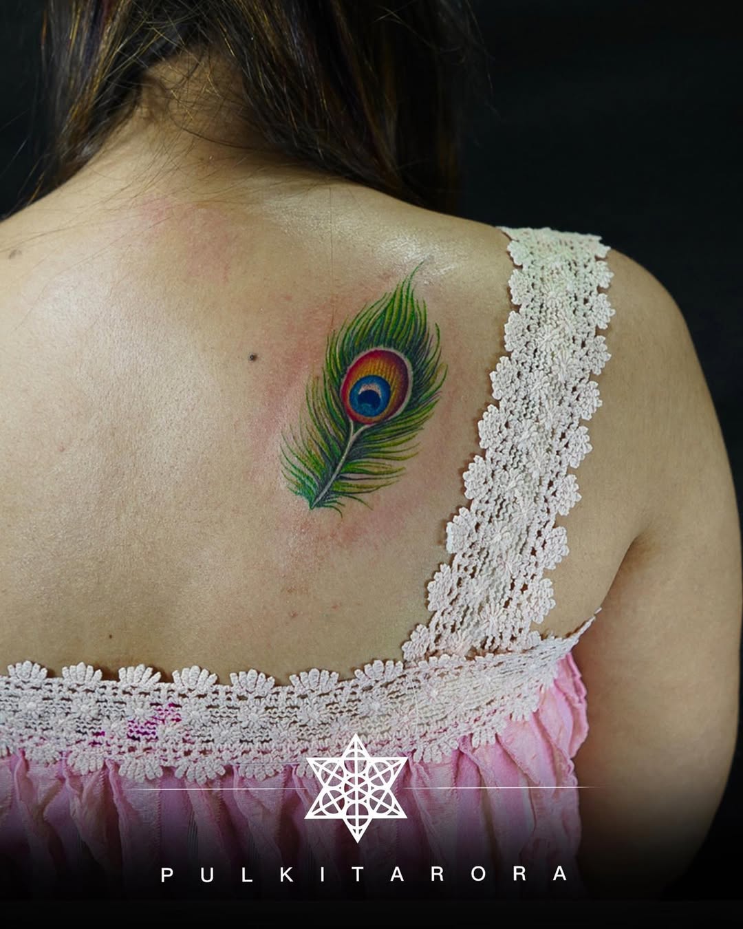 Stunning peacock feather tattoo on the back.