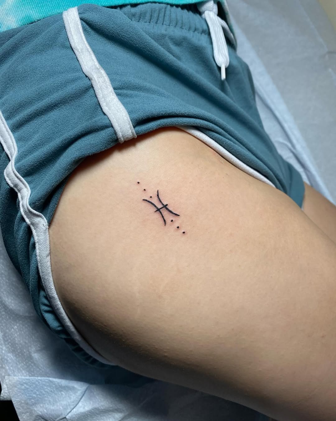 Minimalist Pisces Tattoo Symbol on Thigh