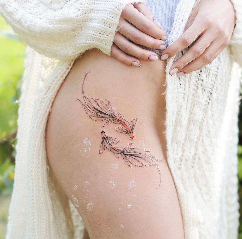 Elegant floral Pisces tattoo with delicate koi fish