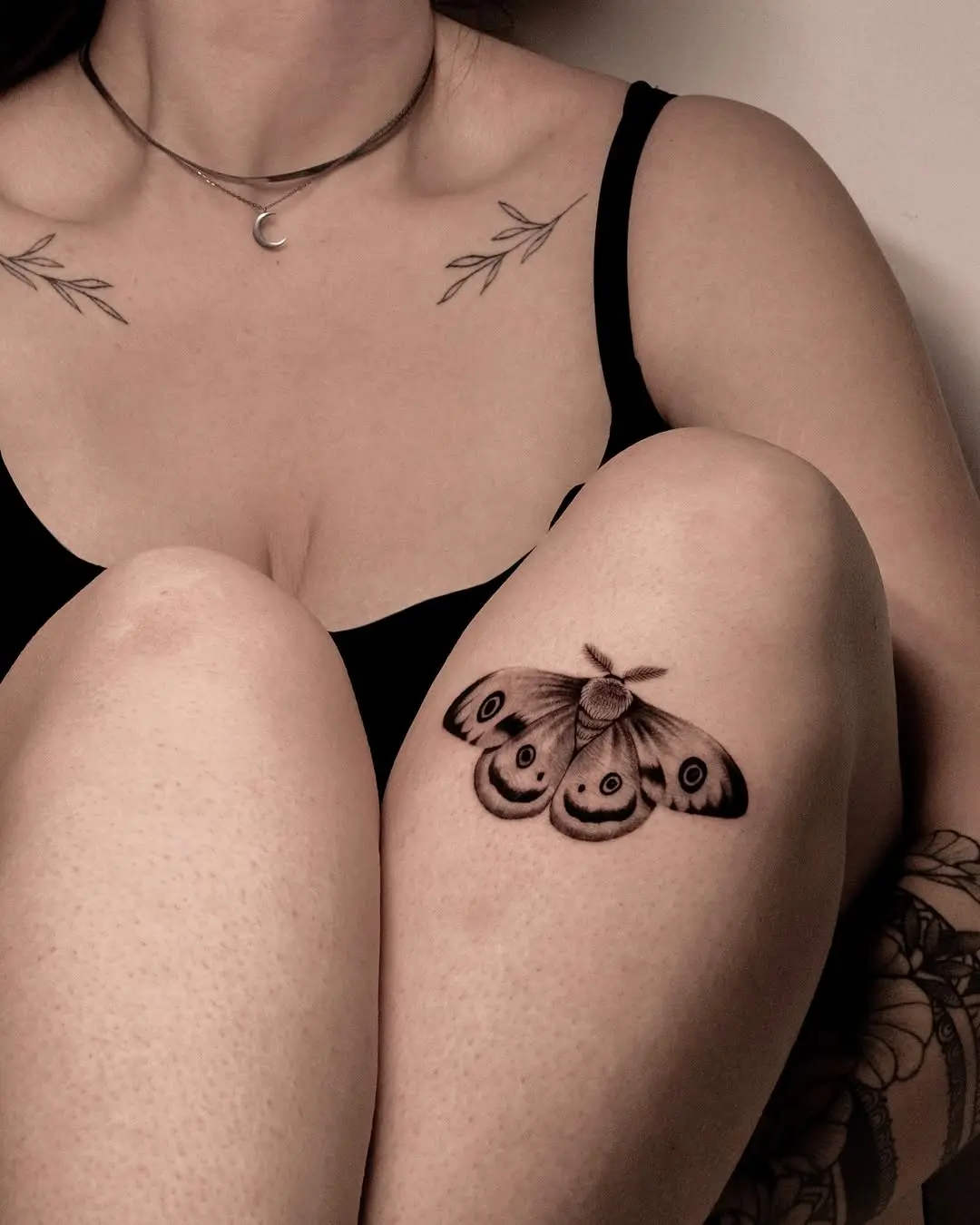 Elegant moth tattoo graces a knee area
