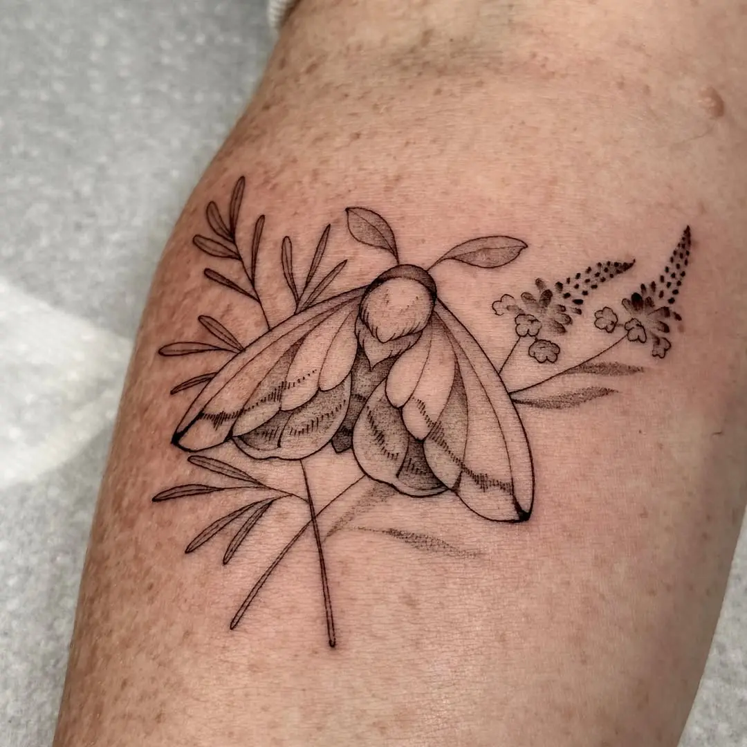 Elegant moth tattoo with floral accents