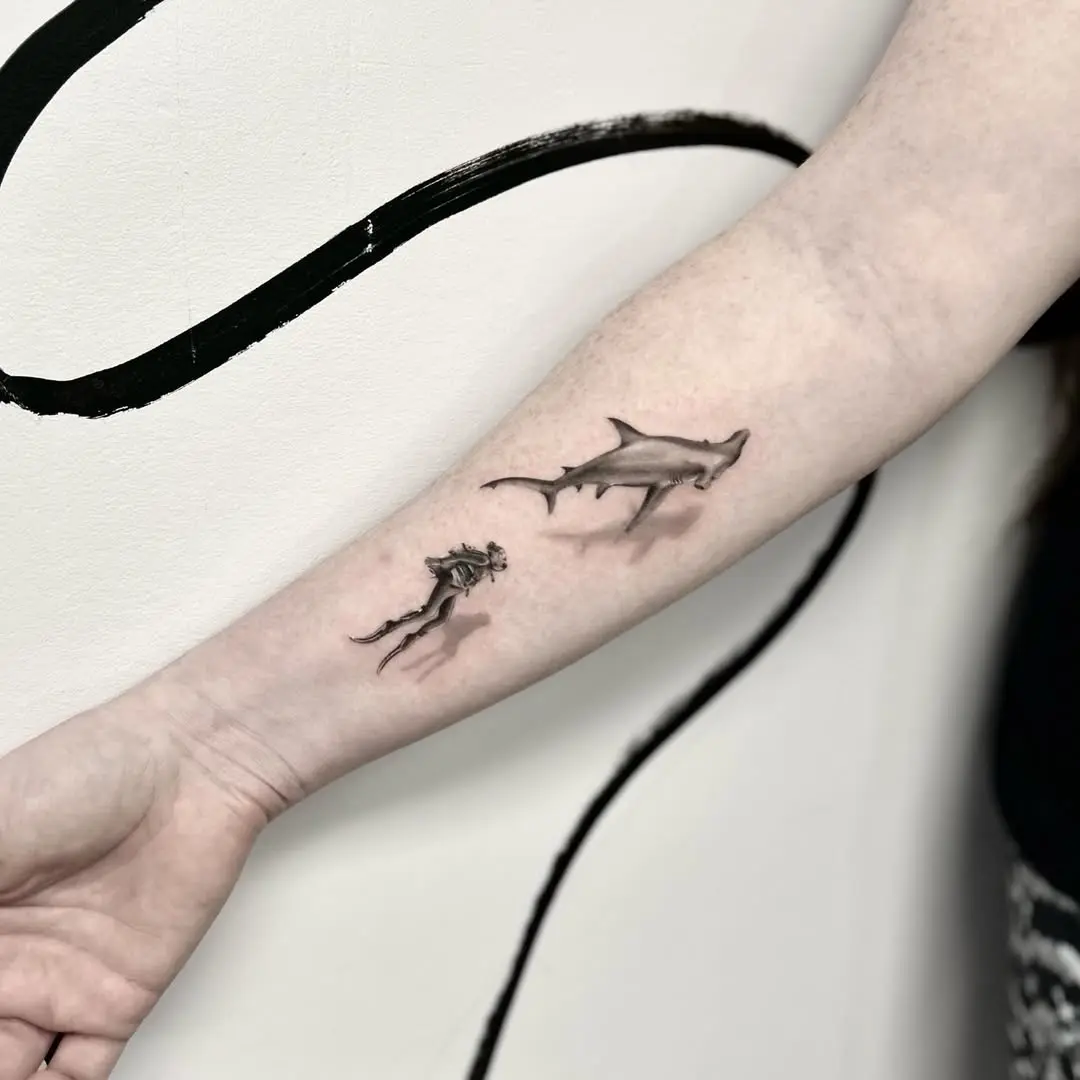 Intricate shark tattoo paired with diver silhouette