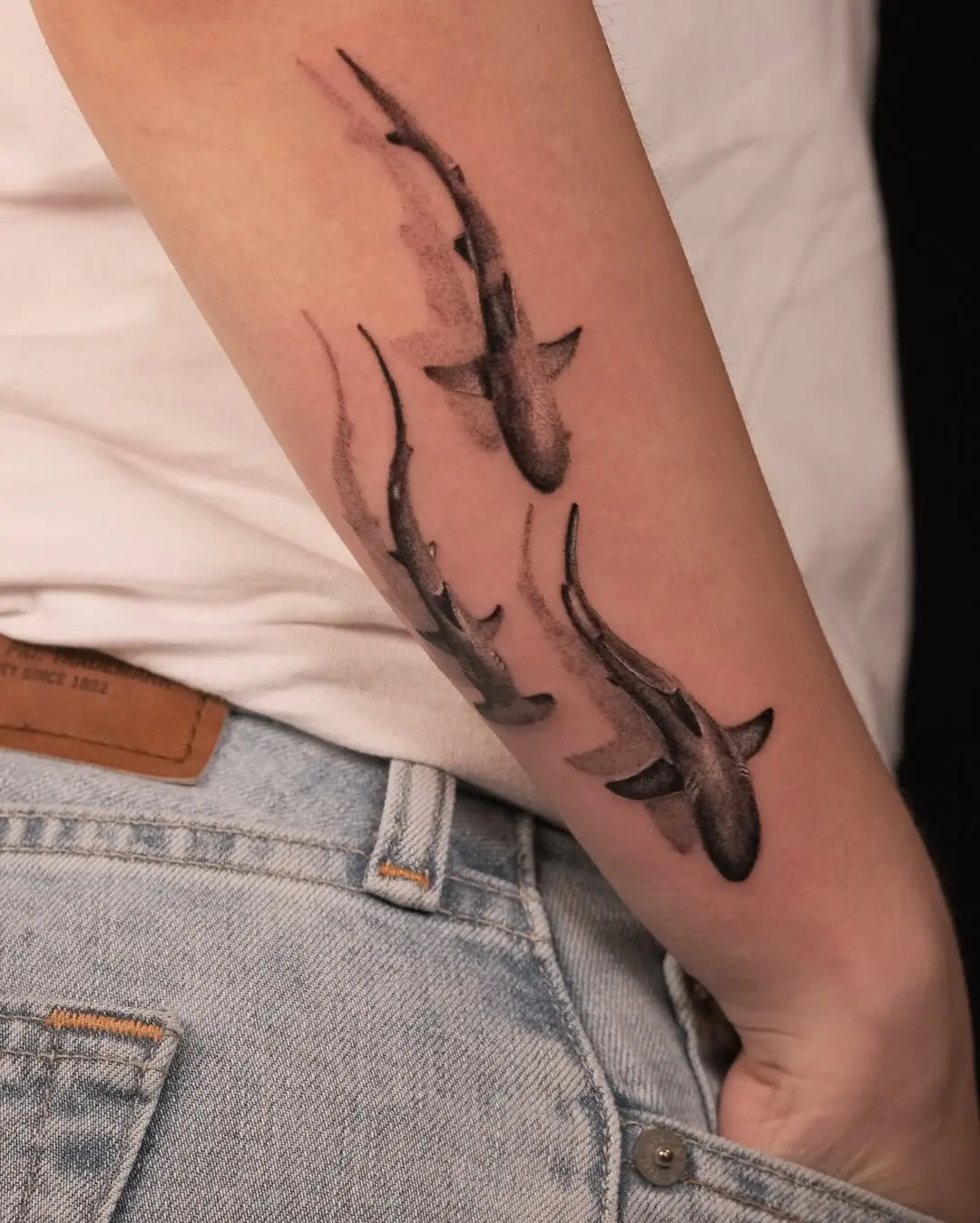 Dynamic shark tattoos creating a flowing effect