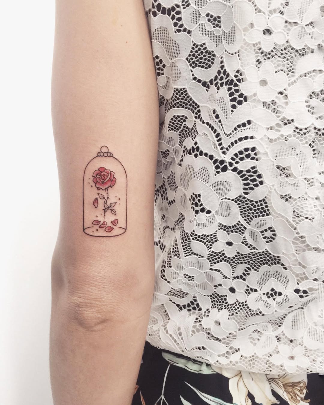 Charming rose tattoo in a whimsical bell jar