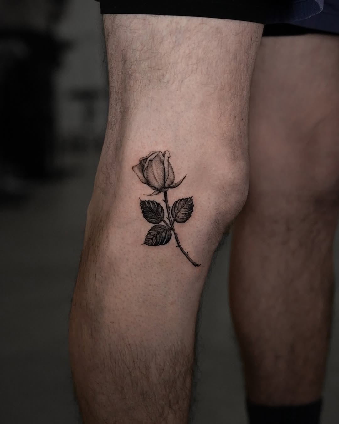 Elegant blackwork rose tattoo on the leg