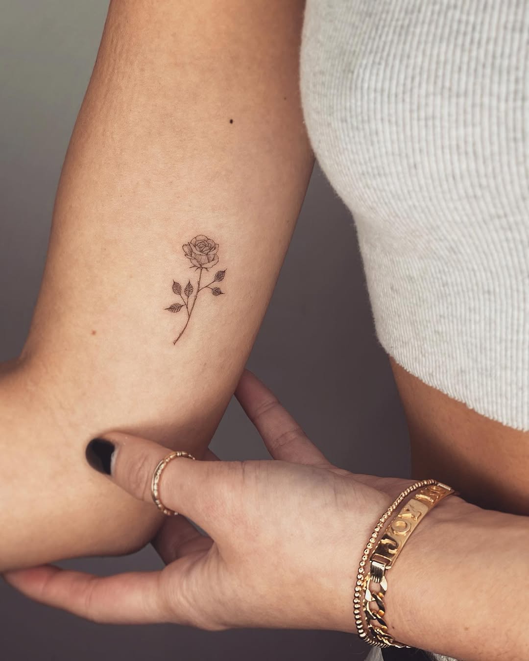 Delicate small rose tattoo on the arm