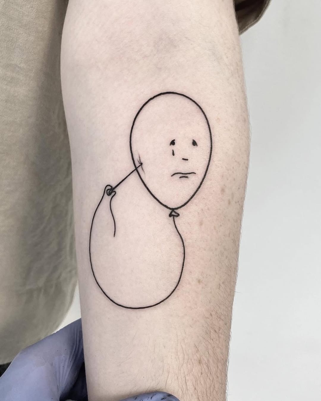 Minimalist tattoo reflecting deep, subtle sadness