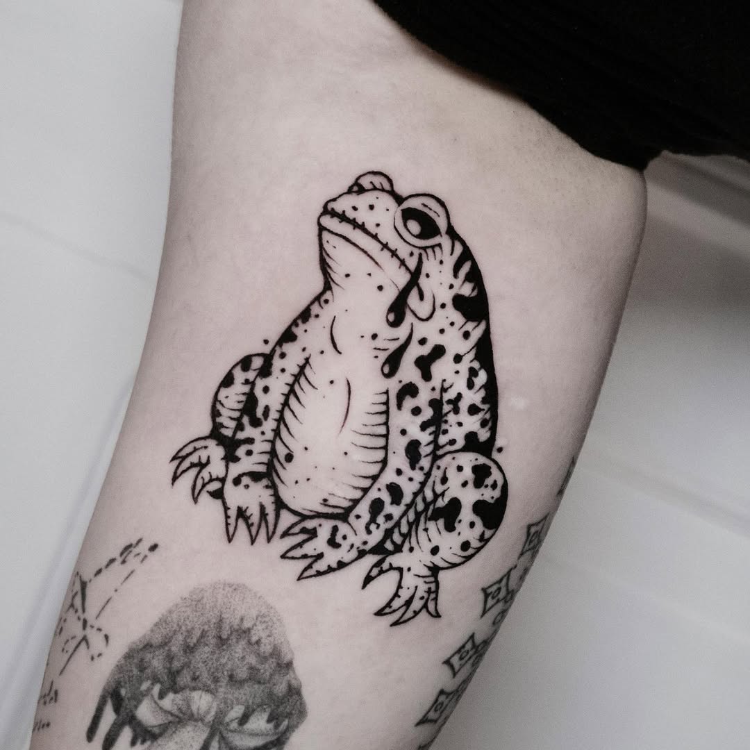 A melancholic frog tattoo capturing lost moments