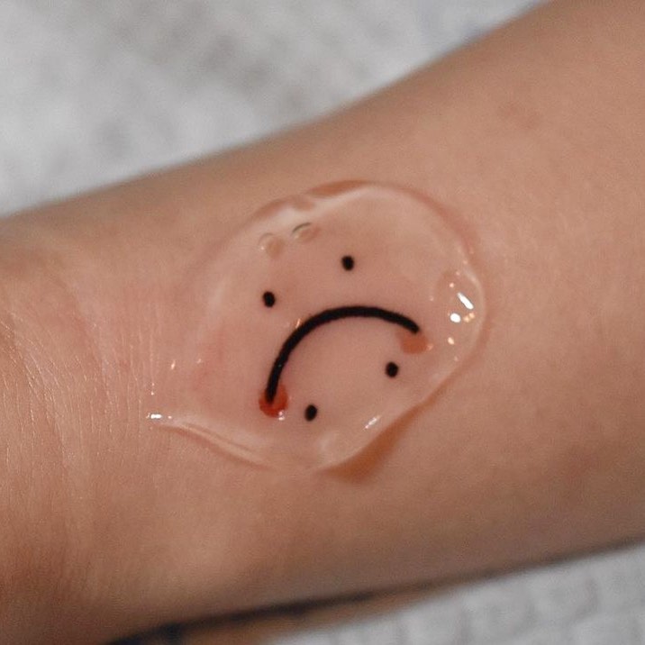 Sorrowful frown symbol inked on skin