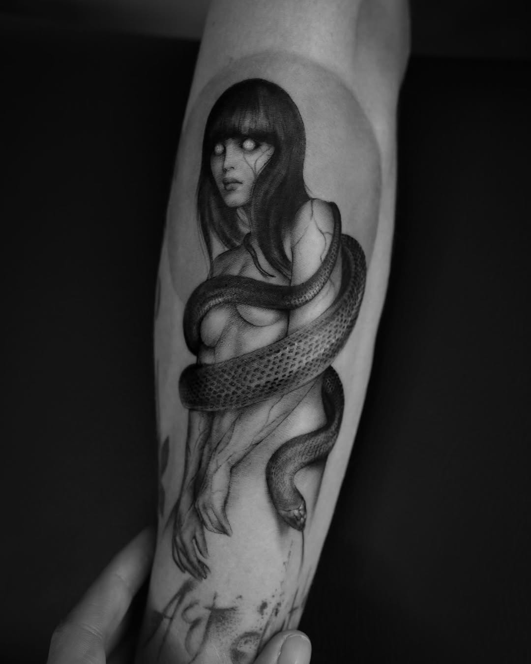 Mysterious woman entwined by a snake tattoo