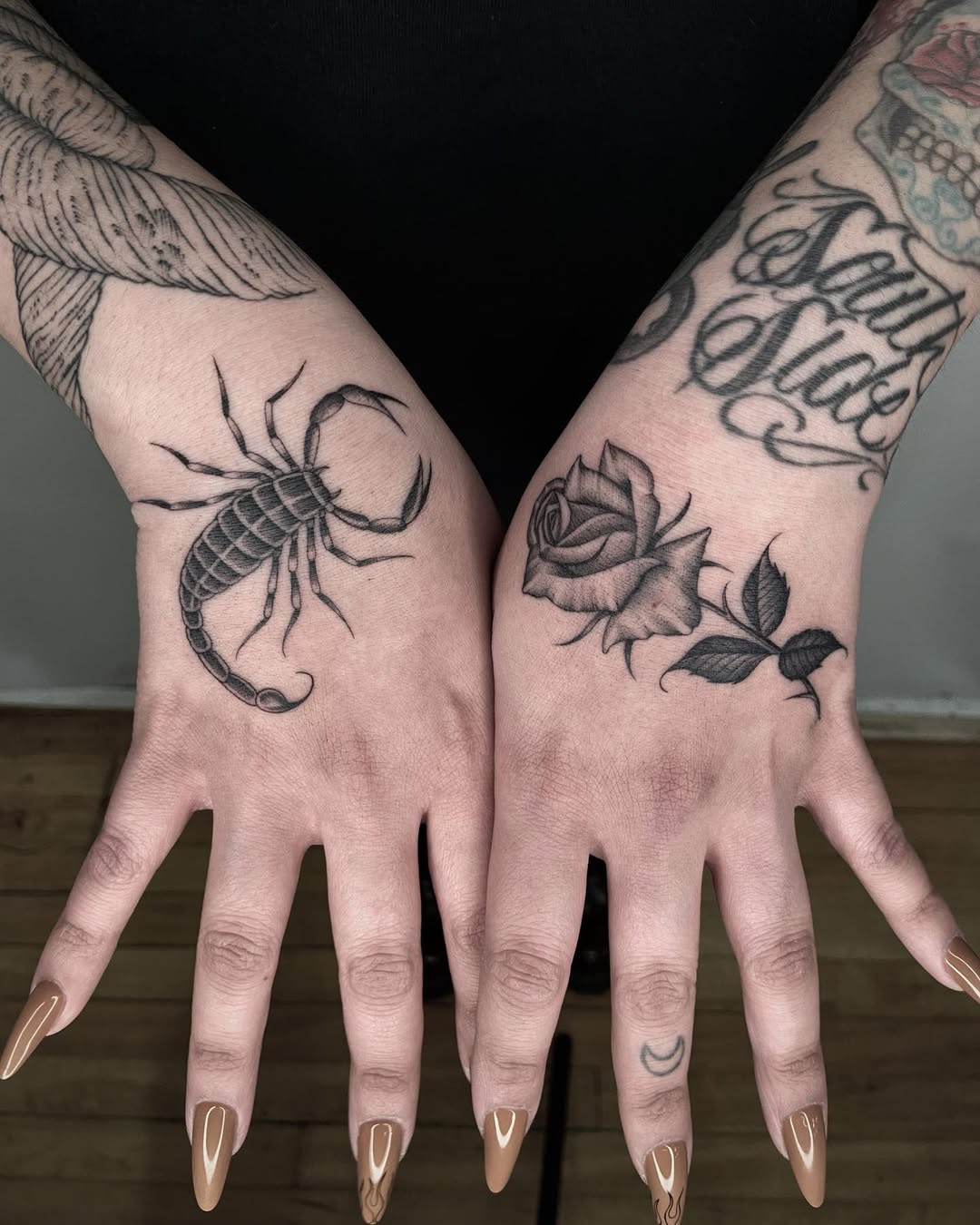 Scorpion and rose tattoo on hands