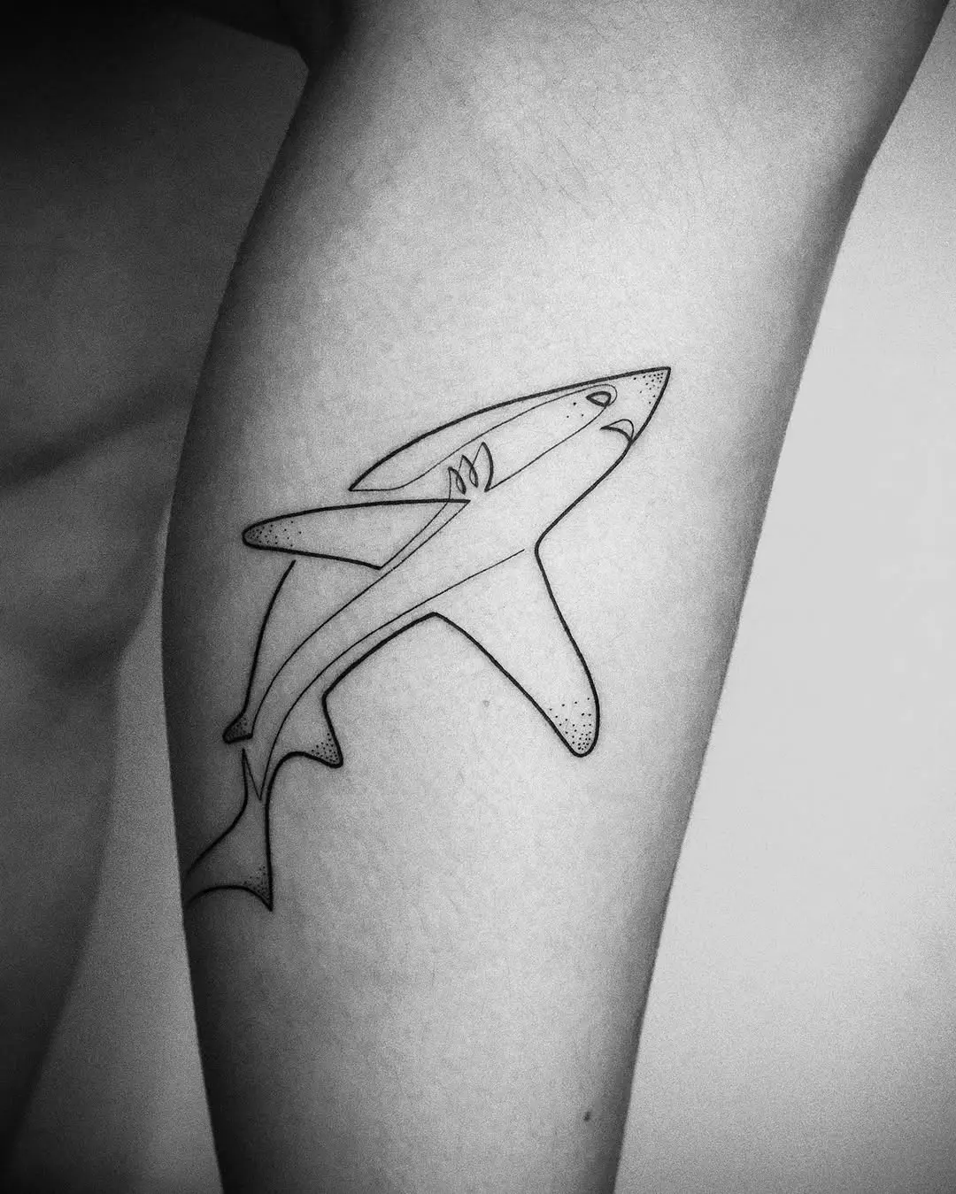 Sleek black and white shark tattoo design