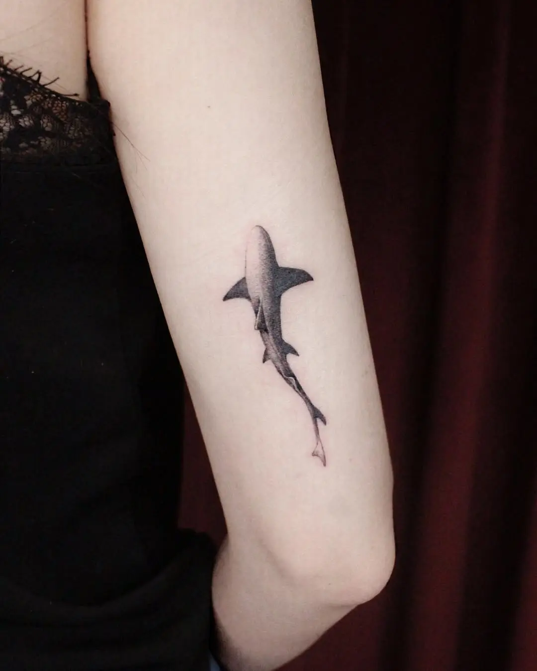 Sleek black ink shark tattoo on arm