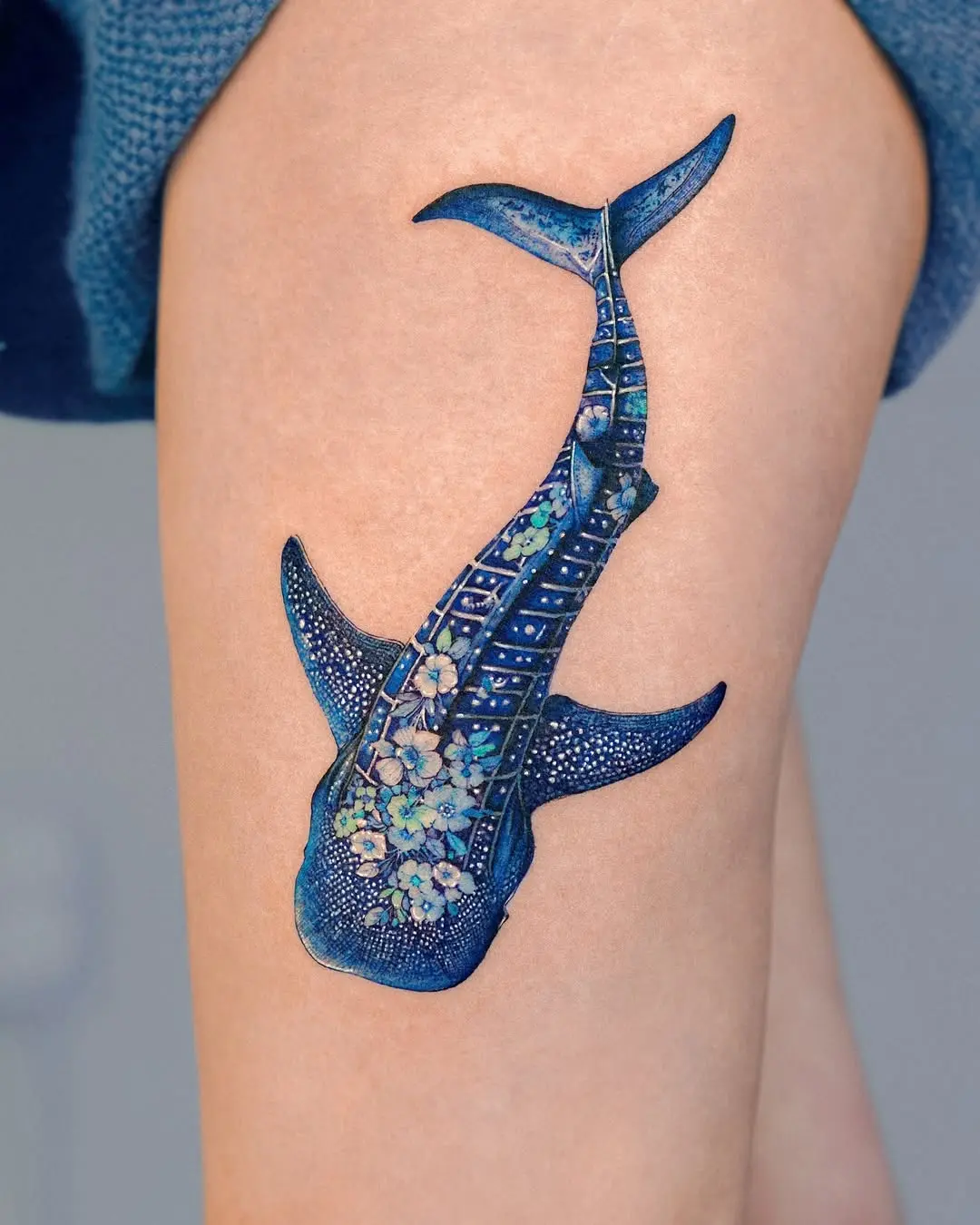 Stunning blue shark tattoo with floral accents