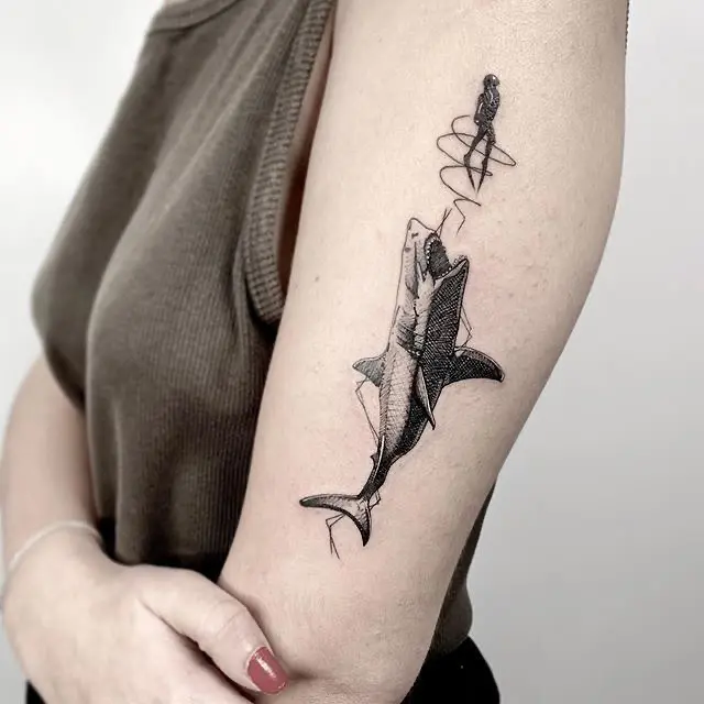 Artistic depiction of a shark and fisherman tattoo