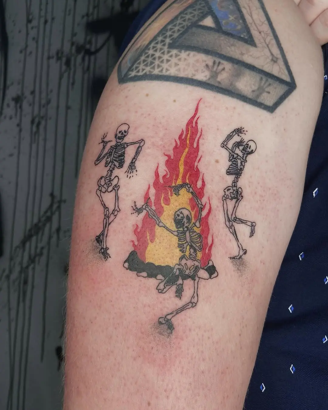 Energetic skeletons celebrate around vibrant flames.