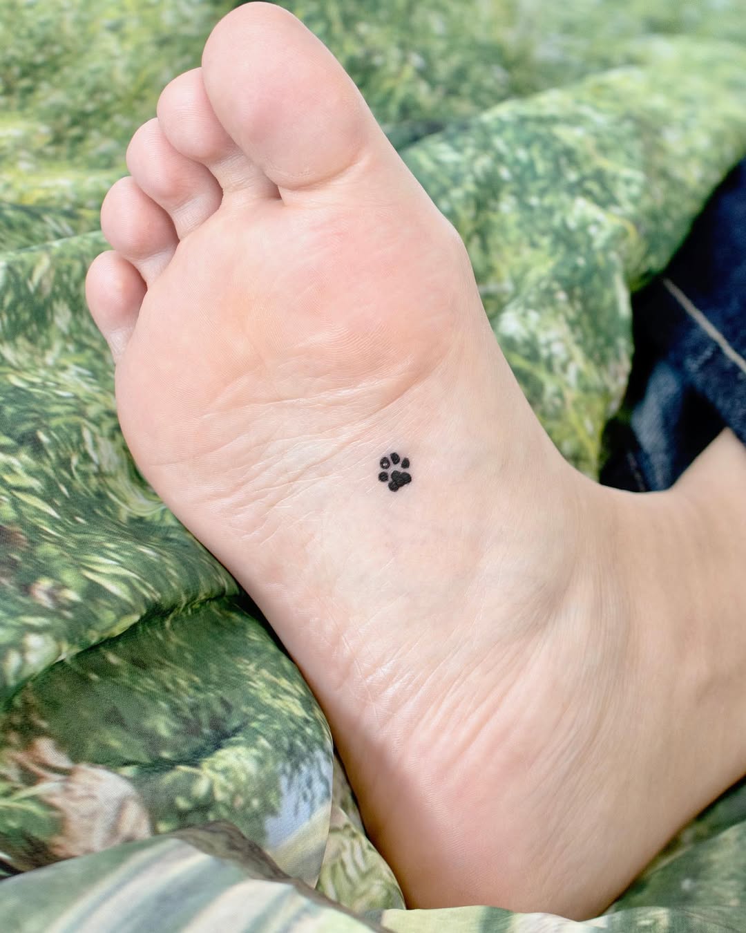 Charming small paw print foot tattoo