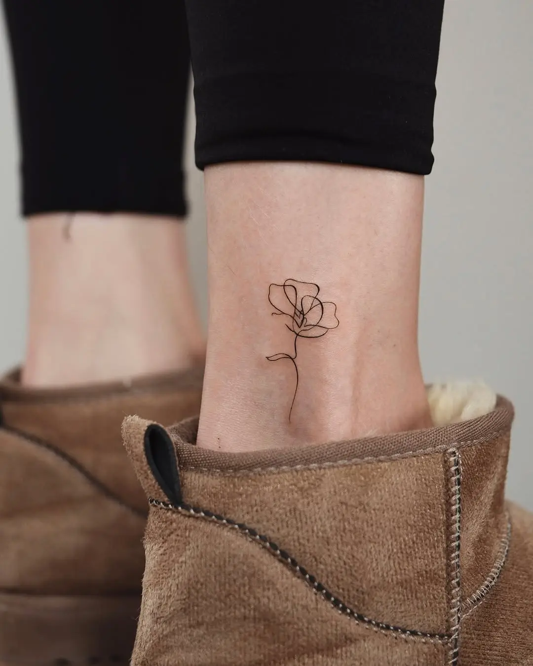 Elegant outline flower tattoo on ankle