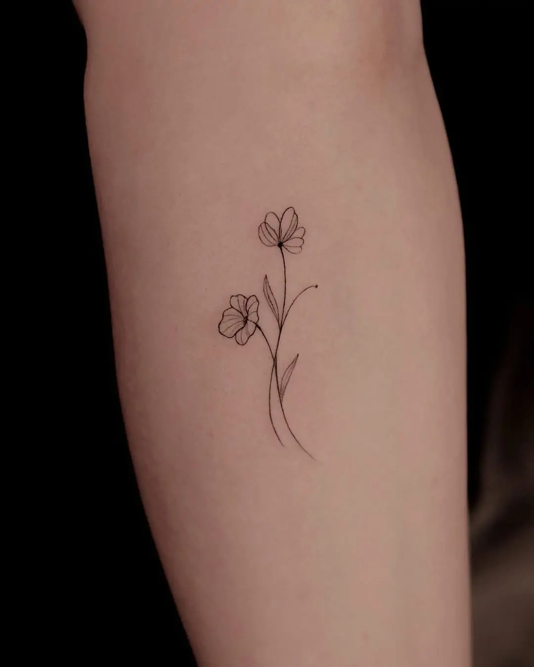 Elegant small flower tattoo for women.