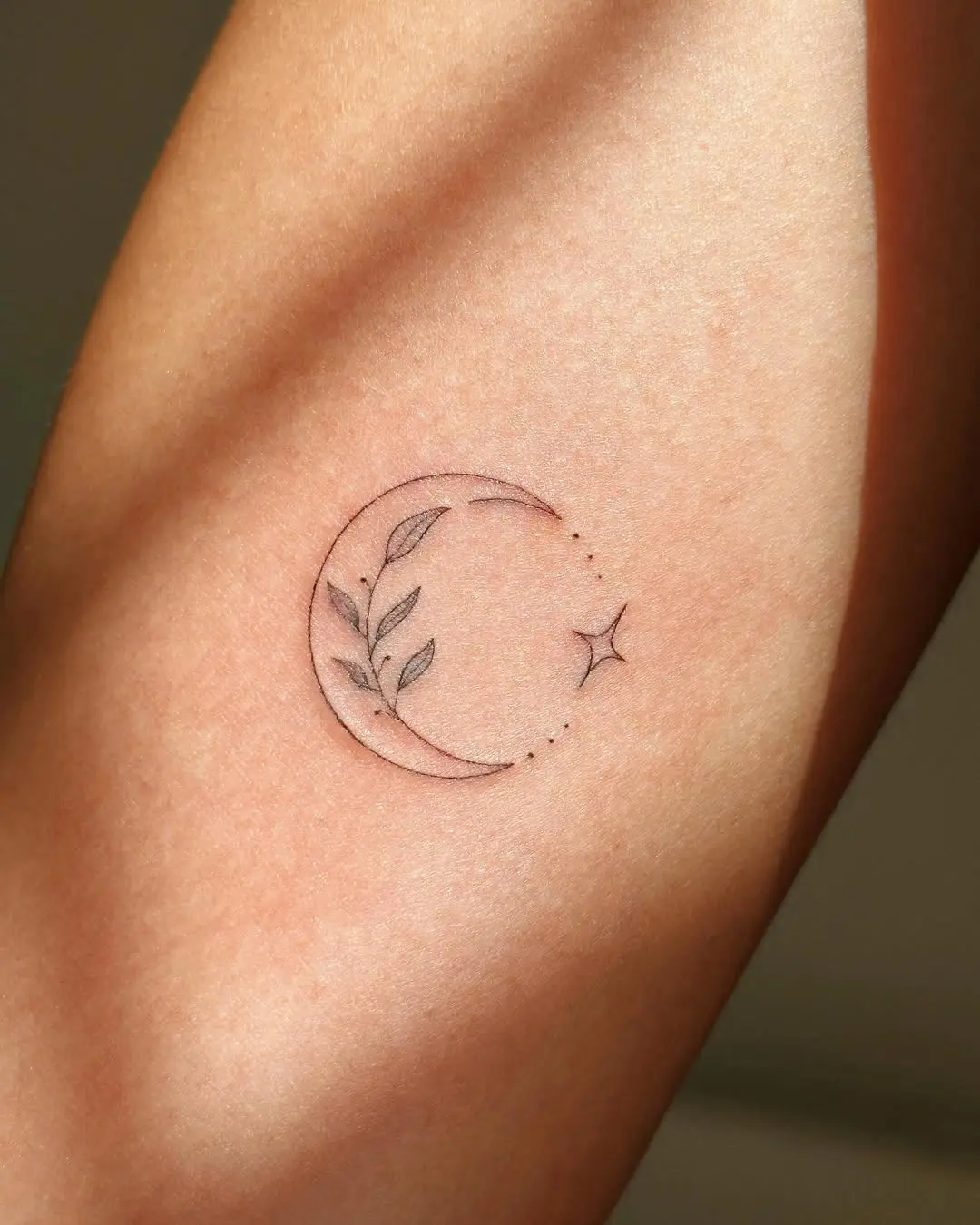 Charming small moon and leaf tattoo design