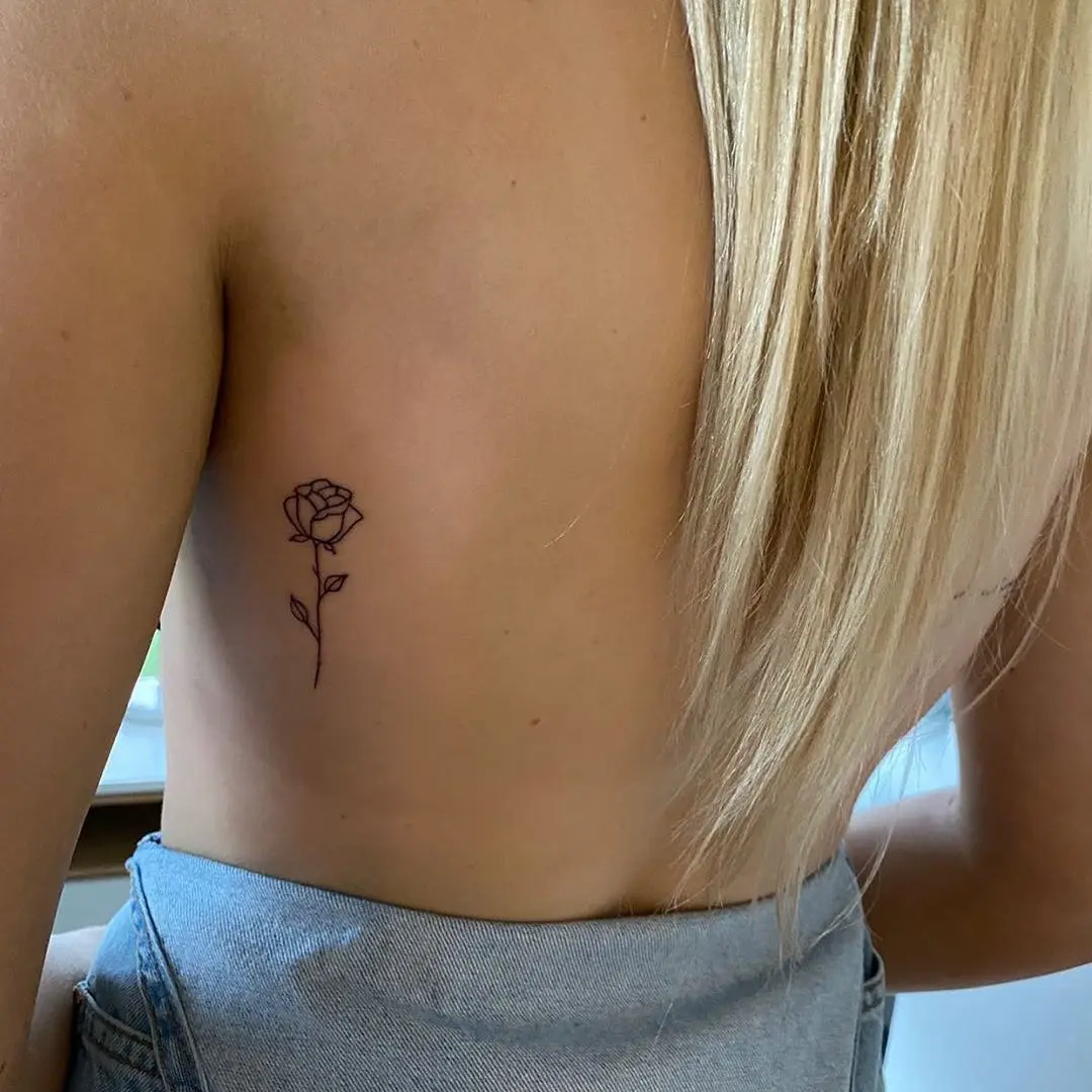 Elegant small rose tattoo on bare skin